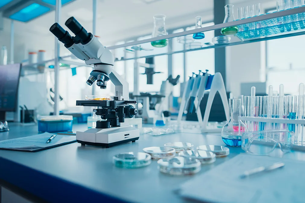 Advanced laboratory setup with a modern microscope, petri dishes, and scientific glassware in a bright, clean research environment
